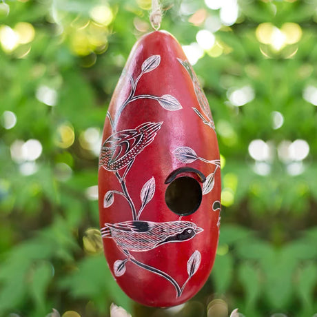 Birds of North America Gourd Birdhouse, handcrafted in Peru with a 1 ¼” opening, drainage holes, and protective coating, hanging from a tree.