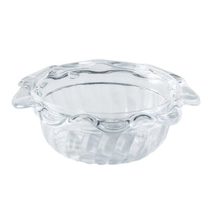 Clear glass pie dish with decorative rim on a white background