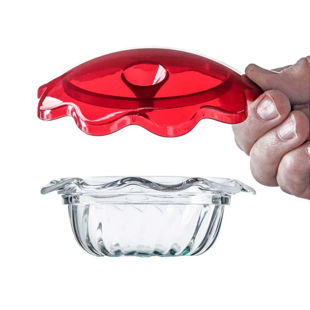 Clear glass dish with a red lid held by a hand on a white background