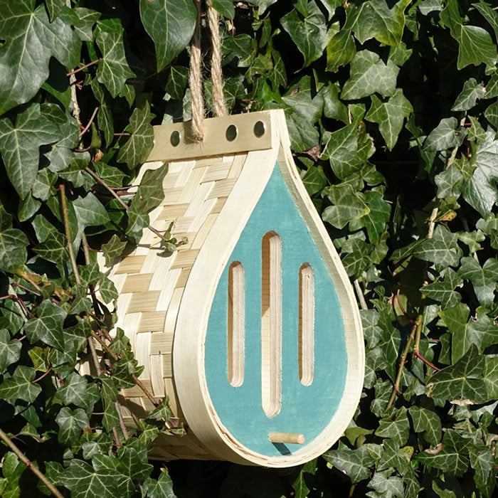 Dewdrop Butterfly House, featuring a dewdrop shape and intricate design, hanging from a tree branch with a jute hanger, blending seamlessly into the garden.