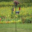 Four Arm Heavy Duty Pole with Twister & Flower Basket, featuring a bird feeder and potted flowers, set up outdoors with birds feeding.