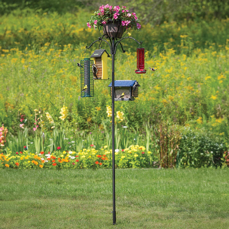 Four Arm Heavy Duty Pole with Twister & Flower Basket, featuring a bird feeder and potted flowers, set up outdoors with birds feeding.