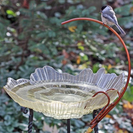 Universal Dripper displayed on a decorative glass birdbath with a songbird on top, highlighting its easy setup and rust-resistant copper-colored stainless steel feature.