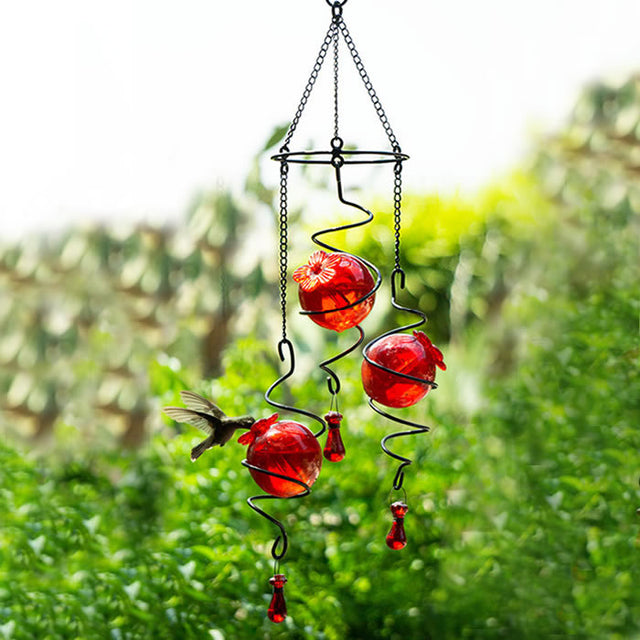 Droplet Spirals 3 Hummingbird Feeder: A mobile with three red glass nectar spheres in a black wire holder, designed to attract and feed hummingbirds in your garden.