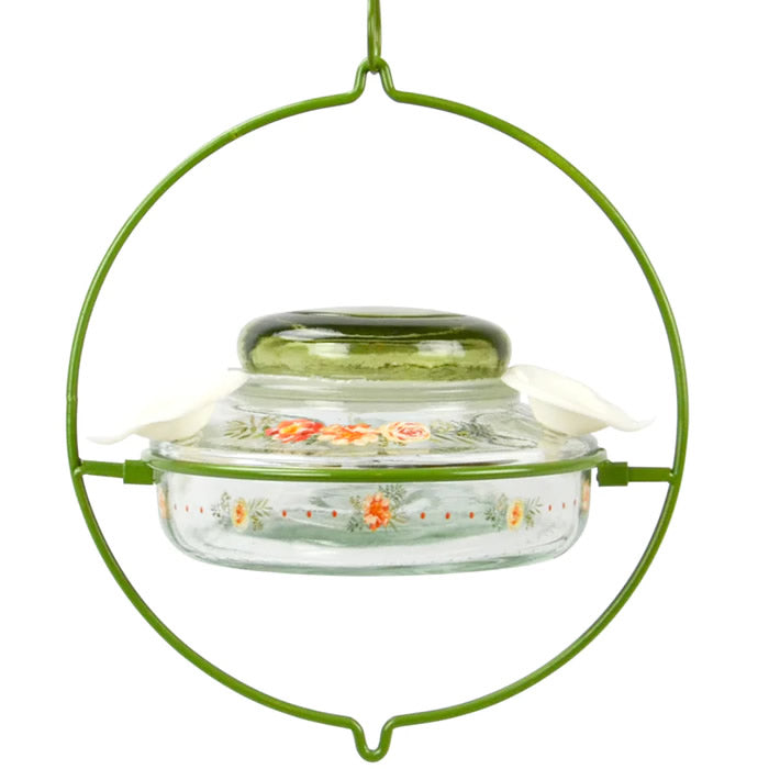 Nature's Way Decorative Top-Fill Glass Hummingbird Feeder, Gardenia Bouquet, featuring a clear glass dish in a wire frame with a green lid and floral feeding ports.