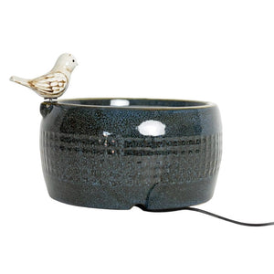 Elloise LED Bird Fountain featuring a distressed white bird perched on a navy blue embossed plaid ceramic bowl with bubbling water and natural pebbles.