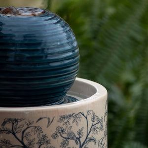 Georgie Chinoiserie Fountain, a ceramic tabletop water feature with a blue and white pattern, ribbed orb top, and water bubbles over the surface.