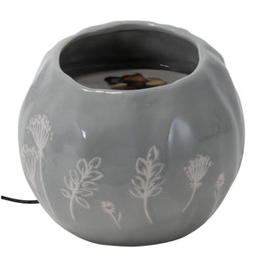 Wildflower Fountain: A gray ceramic orb fountain with a botanical pattern, featuring a bubbling water top, pebbles, and a black cord for easy plug-in use.