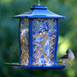 Nature's Way Paisley Sky Gazebo Metal Bird Feeder with extended perches and built-in seed diverter, holding 4 lbs. of seed, shown attracting a bird.