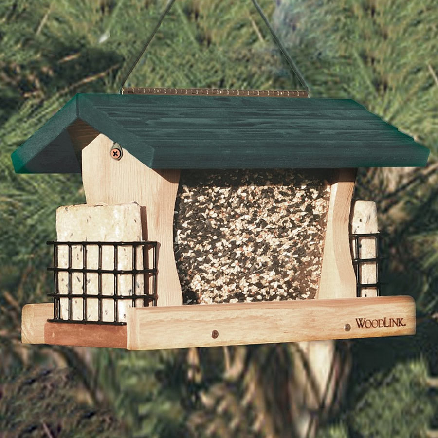 Large Cedar Hopper with Suet Cages hanging from a tree, filled with seeds, featuring a green roof and clear plastic panels for easy seed level viewing.