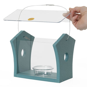 Hand holding Bluebird Feeder in Blue Recycled Plastic with clear sides and dish, designed to attract bluebirds by feeding mealworms.