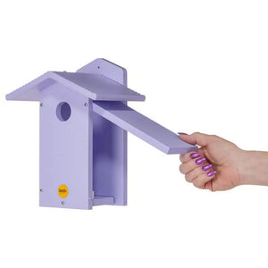 Hand holding the Purple Bluebird House made from durable, recycled plastic with a side door for cleaning and a 1-1/2 inch entrance hole.