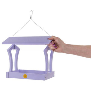 Hand holding Fly-Thru Bird Feeder, showcasing its wide open platform and durable construction with stainless steel fasteners and a perforated steel tray for optimal bird feeding.