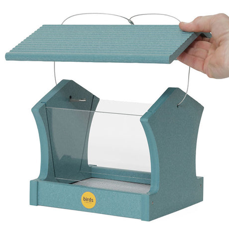 Hand holding the Medium Hopper Bird Feeder, Lake Blue, showcasing its plexi-glass windows and side perching for various bird sizes.