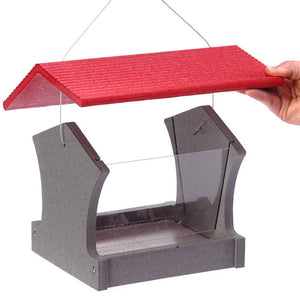 Hand holding a Medium Hopper Bird Feeder with clear plexi-glass windows and red roof, designed to attract various bird sizes and hold up to 3 lbs. of seed.