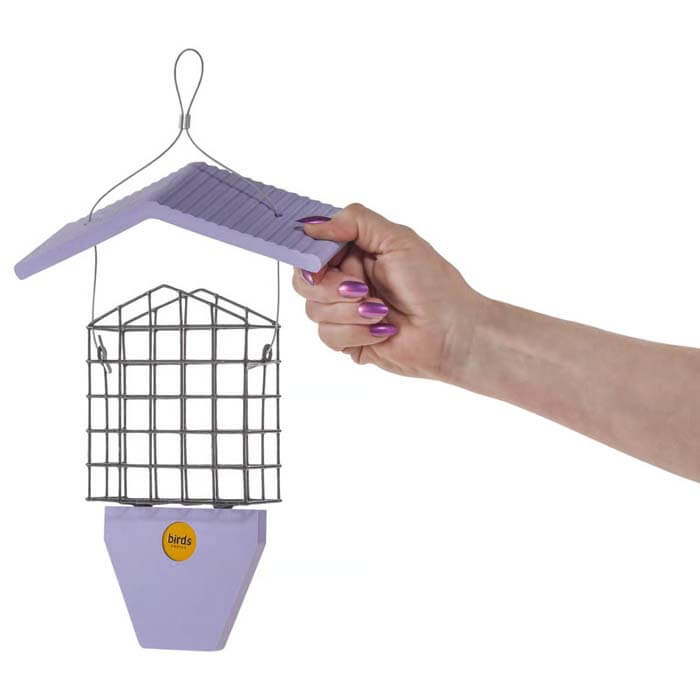 Hand holding the Suet Feeder with Tail Prop, Purple, featuring a suet cage and a top-lifting roof for easy refilling.