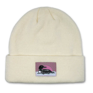 Bird Collective Loon Cuffed Beanie, Ivory: A cozy, white beanie featuring a loon design patch, perfect for bird enthusiasts and nature lovers, ensuring warmth and comfort.