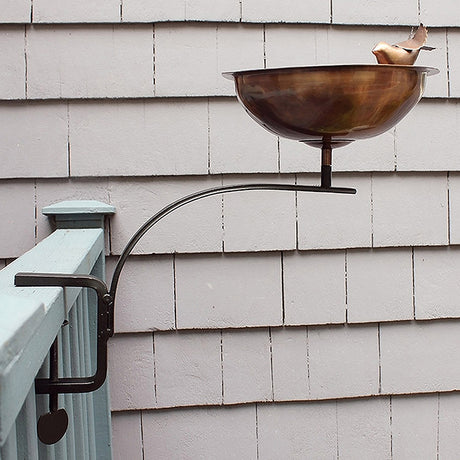 Heart Shaped Bird Bath with Rail Mount Bracket featuring a decorative bird accent, securely attached to a deck railing, perfect for easy bird watching.