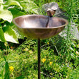 Heart Shaped Bird Bath with Stake in a garden, featuring a copper-plated basin, decorative dove, and wrought iron stake.