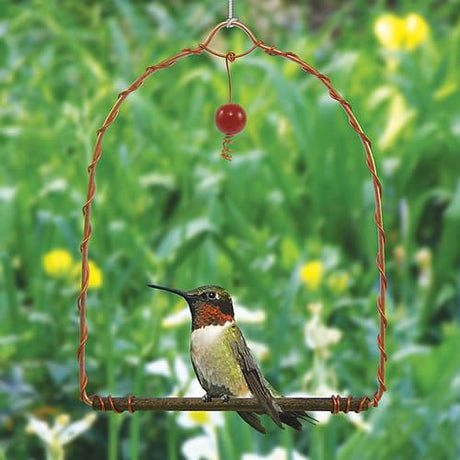 Copper Hummingbird Swing with a red bead dangler, featuring a hummingbird perched on it, designed to attract and provide a resting spot for hummingbirds.