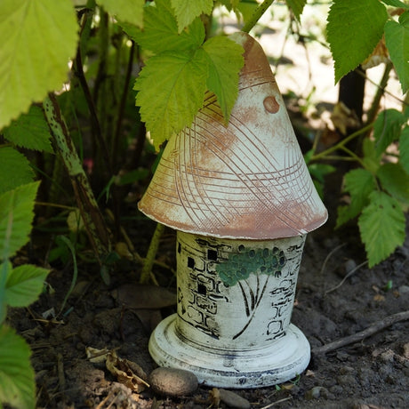 Ladybug Castle: A small ceramic structure with a cone-shaped roof, designed for garden ladybugs, made from durable stoneware for outdoor use.