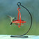 Sphere Hummingbird Set: A hummingbird feeds from a minimalist sphere feeder on a tabletop steel hanger, designed for close-up viewing and easy maintenance.