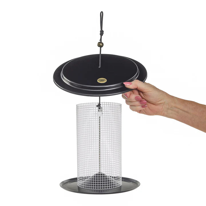 Hand holding a Modern Farmhouse Sunflower Seed Bird Feeder, Black and White, showcasing its cylindrical mesh design and black handle for bird feeding.