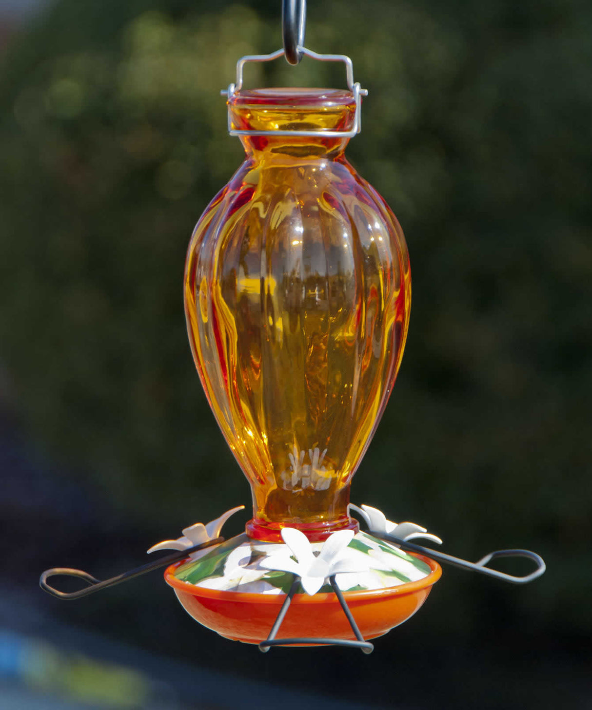 Fluted Glass Oriole Feeder with a fluted glass reservoir, decorative white flower blossoms, and three feeding ports, featuring a metal hanger and a no-drip design.