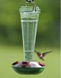 8 oz. Torchiere Glass Hummingbird Feeder with embossed floral scrollwork on a green glass bottle, featuring red flower-shaped feeding ports and a twist-off base for easy cleaning.