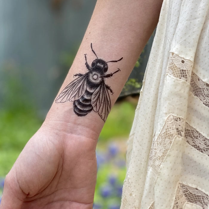 Big Bee Temporary Tattoo on wrist, featuring a detailed bee design, hand-drawn by Allison Wilcoxen. Temporary, water-resistant, and skin-safe, lasting 2-5 days.