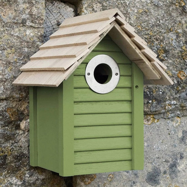 New England Nest Box on rock wall, featuring real shingle roofs, lapboard sides, and a circular entrance hole, ideal for small birds.