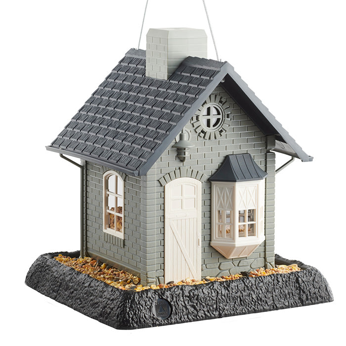 North States Bayside Cottage Bird Feeder featuring a small grey house with white door, black roof, bay window, large feeding tray, and lift-off chimney.