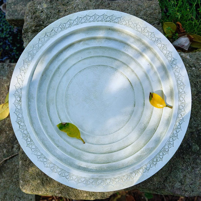 Nature Oasis Bird Bath, a white platter with yellow leaves, made from recycled plastic and bamboo fibers, providing water for birds and insects.