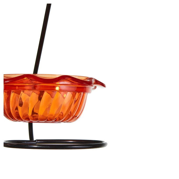 Orange bird feeder with black stand on a white background