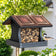 Modern Farmhouse Vintage Wood with Tin Roof Hopper Feeder showcasing a bird perched on it. Feeder design supports various birds and holds up to 4 lbs of seed.