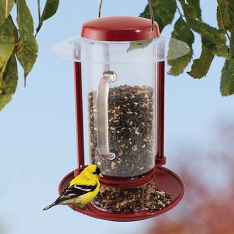 Combination Hopper & Seed Scoop Feeder with a yellow bird perched on it, showcasing the built-in seed tray and easy-fill handle.