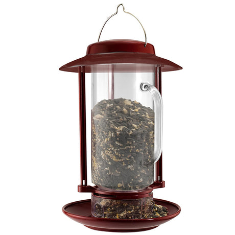 Combination Hopper & Seed Scoop Feeder featuring a glass container filled with seeds. The removable seed reservoir doubles as a scoop for easy filling.