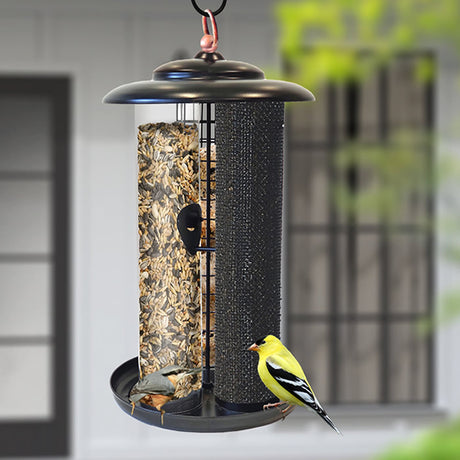 Modern Farmhouse Triple Tube Combination Feeder with yellow bird perched on feeder, offering Nyjer®, mixed seeds, and suet balls with metal perches and deep tray.