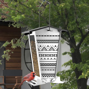 Snack Shack Nordic Habitat Squirrel-Resistant Feeder with a bird eating from the feeder, showcasing weight-activated perches and clear plastic windows for seed visibility.