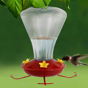 24 oz. Plastic Trumpet Flower Hummingbird Feeder with clear reservoir, red base, yellow flower ports, and built-in perches; hummingbird feeding from one of the ports.