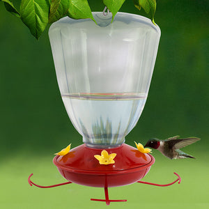 32 oz. Plastic Trumpet Flower Hummingbird Feeder with a clear plastic reservoir, red base, yellow feeding ports, and built-in hanger, attracting a perched hummingbird.