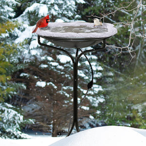 20 Heated Bird Bath with Metal Stand in snowy outdoor setting, featuring a red bird on the basin. Keeps water ice-free with a built-in thermostat.