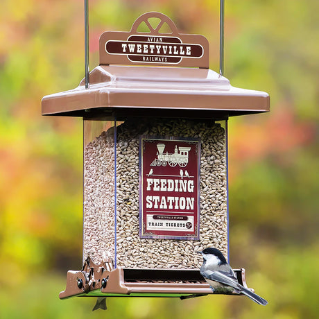 Rustic Farmhouse Train Feeding Station Squirrel-Resistant Feeder with a bird perched on it, featuring weight-sensitive perches and a locking roof, hanging outdoors.