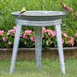 Vintage Galvanized Metal Bird Bath with embossed lines, three-leg stand, and built-in perching space, featuring birds sitting and preening on the basin.