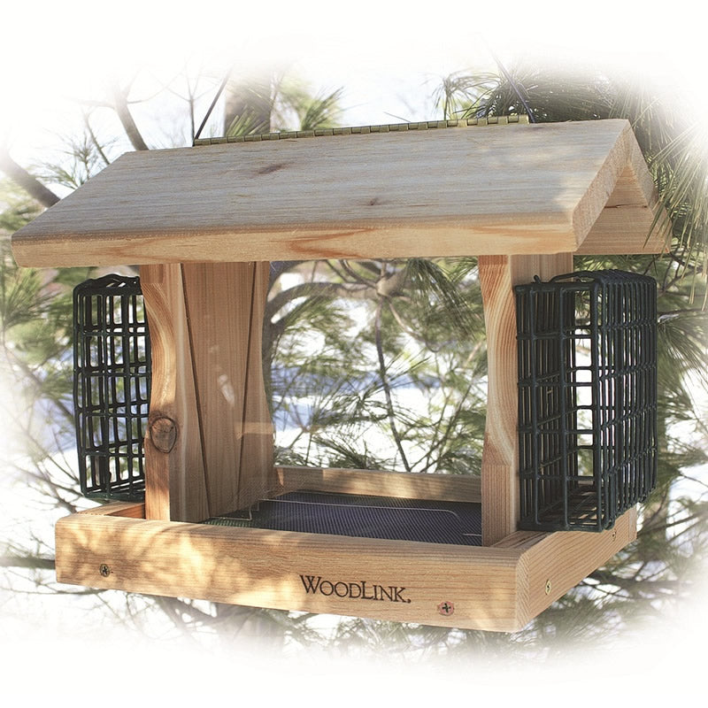 Premier Cedar Feeder with Suet Cages hanging from a tree, showcasing wooden construction, metal mesh flooring, two feeding trays, and a cable hanger.