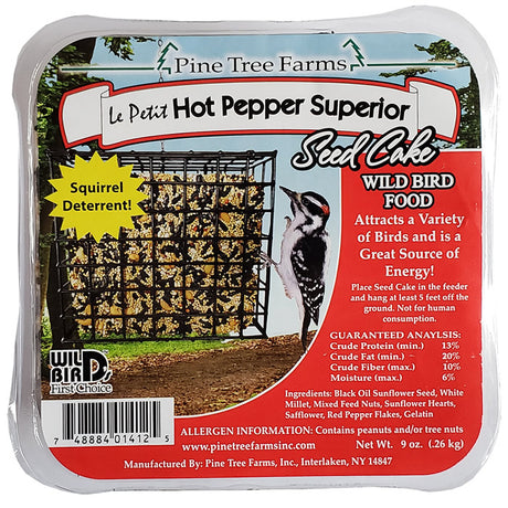 Le Petit Hot Pepper Superior Seed Cake, Set of 4, shown in a plastic container with a bird feeder and a black and white bird nearby.