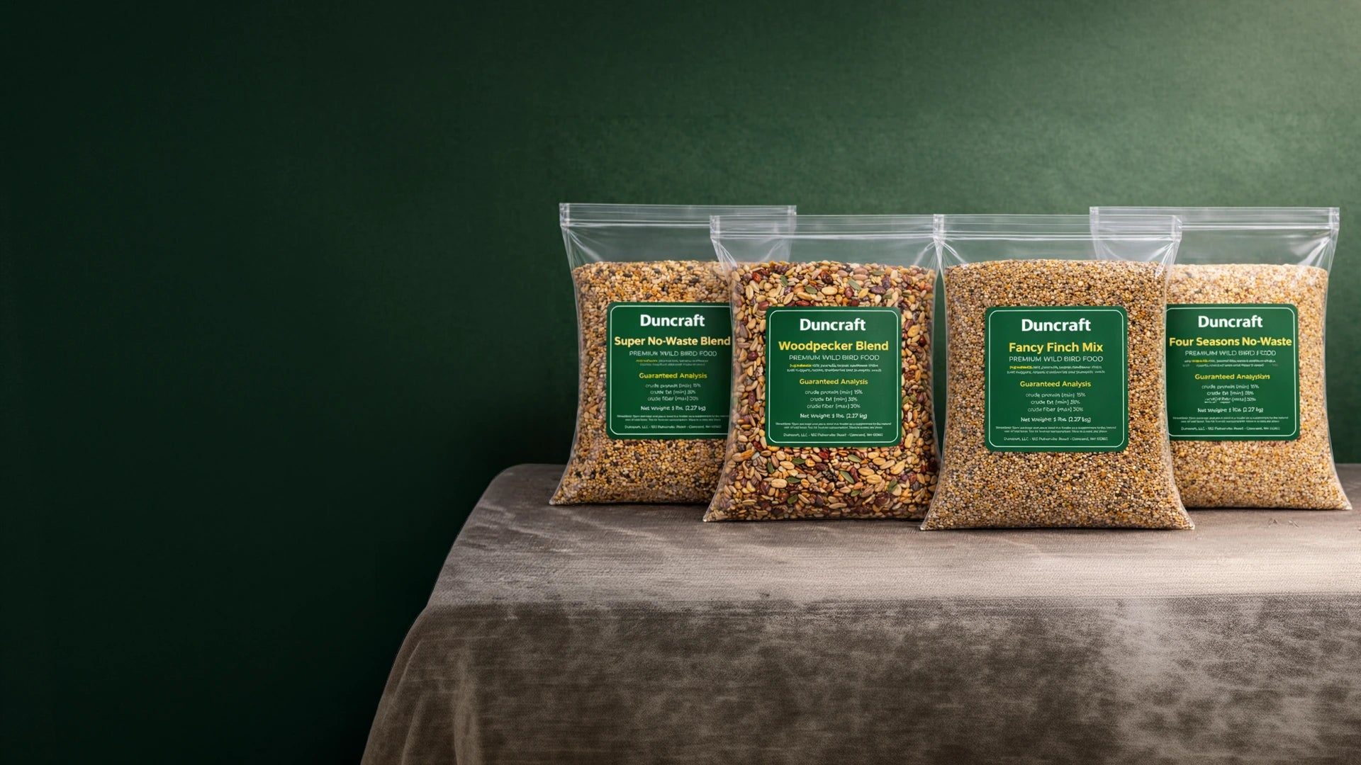4 bags of birdseed against a green background.