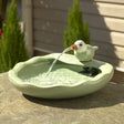 Ceramic Bird Solar Fountain on a stone surface with water flowing from the bird's mouth into the bowl. Powered by solar panel, perfect for gardens or patios.