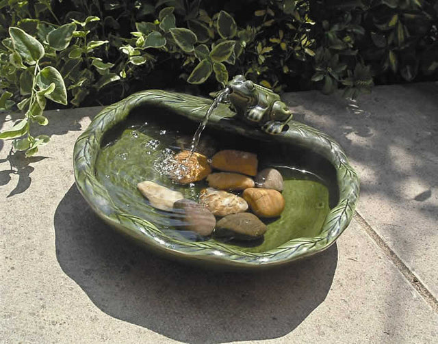 Ceramic Frog Solar Fountain with water flowing from the frog's mouth into a bowl, powered by a solar panel for continuous recycled water flow.