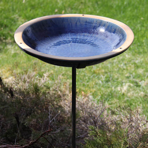 Post Radial Bird Bath, Baywater Blue, in a garden setting, featuring a stoneware basin on a black steel pole, perfect for attracting birds.